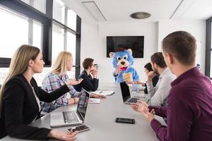 als bär verkleideter chef hat spaß mit geschäftsleuten im trendigen büro foto