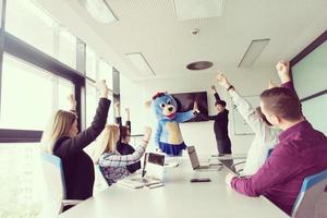 als bär verkleideter chef hat spaß mit geschäftsleuten im trendigen büro foto