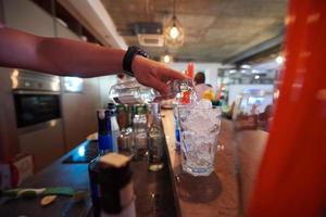 barmann bereitet frisches coctailgetränk zu foto