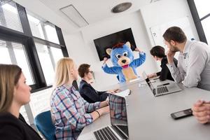 als bär verkleideter chef hat spaß mit geschäftsleuten im trendigen büro foto