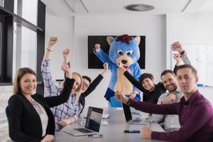 als bär verkleideter chef hat spaß mit geschäftsleuten im trendigen büro foto