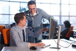 zwei geschäftsleute, die mit computer im büro arbeiten foto