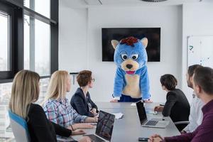 als bär verkleideter chef hat spaß mit geschäftsleuten im trendigen büro foto