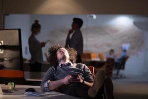 Geschäftsmann sitzt mit Beinen auf dem Schreibtisch im Büro foto