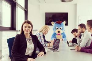 als bär verkleideter chef hat spaß mit geschäftsleuten im trendigen büro foto