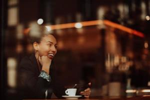 Latina-Frau, die in einer Pause von der Arbeit in einem Café sitzt foto