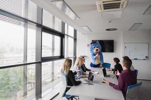 als bär verkleideter chef hat spaß mit geschäftsleuten im trendigen büro foto