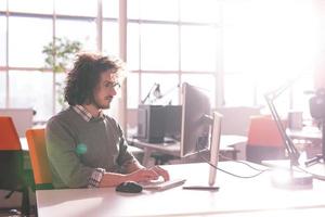 Geschäftsmann, der mit einem Computer im Startup-Büro arbeitet foto