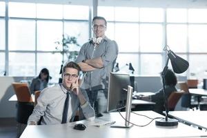 zwei geschäftsleute, die mit computer im büro arbeiten foto