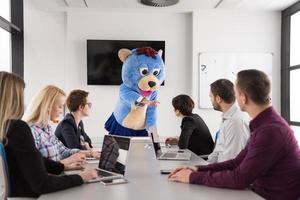 als bär verkleideter chef hat spaß mit geschäftsleuten im trendigen büro foto