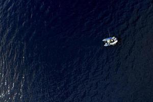 Schlauchboot mit Fischern mitten in der Draufsicht des Sees foto