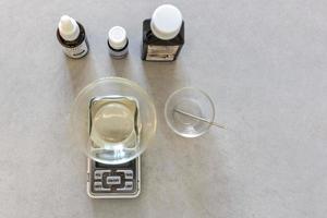 ein Seifenhersteller wiegt aromatische Öle für die Herstellung von Kosmetika auf einer Küchenwaage. Spa zu Hause. Kleinunternehmen foto