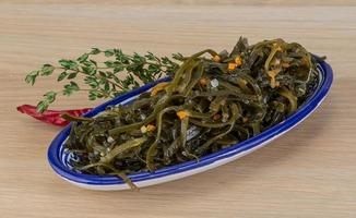 Laminaria-Salat in einer Schüssel auf Holzhintergrund foto