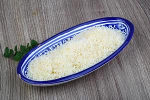 zerkleinerter Parmesan in einer Schüssel auf Holzhintergrund foto