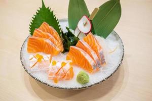 Frisches Lachsscheiben-Sashimi, serviert auf Eis mit Wasabi nach japanischer Art foto