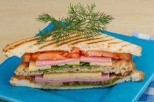 Club-Sandwich auf dem Teller und Holzhintergrund foto