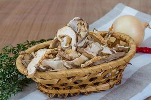 Shiitake in einem Korb auf Holzhintergrund foto