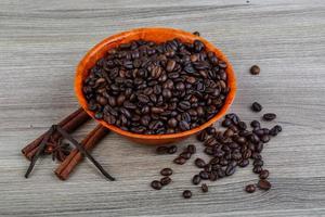 Kaffeebohnen in einer Schüssel auf hölzernem Hintergrund foto