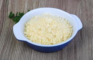 zerkleinerter Parmesan in einer Schüssel auf Holzhintergrund foto