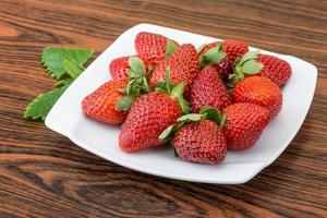 frische Erdbeere auf dem Teller und Holzhintergrund foto