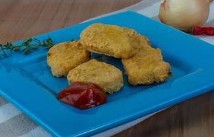 Nuggets auf dem Teller und Holzhintergrund foto