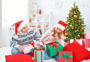 glückliches Familienpaar mit einem Geschenk an Weihnachten zu Hause foto