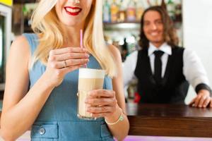 Barista mit Kunden in seinem Café oder Coffeeshop foto