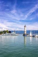 lindau, deutschland - 21. juli 2019. schiff segelt weg von der malerischen hafenstadt lindau am bodensee. vertikale ansicht foto