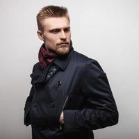 eleganter junger hübscher Mann im schwarzen Mantel. Studio Mode Porträt.
