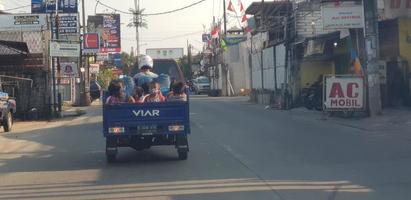 west java im april 2019. eine gruppe von kindern fährt auf einem dreirad, hinter dem sich ein schiff befindet. foto