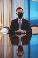 Geschäftsmann mit schützender Gesichtsmaske im Luxusbüro foto