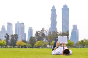 junge Frau, die ein Buch im Park liest foto