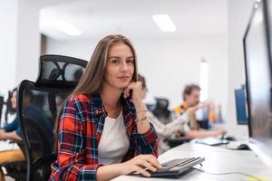 Lässige Geschäftsfrau, die an einem Desktop-Computer in einem modernen Großraum-Startup-Büro arbeitet. selektiver Fokus foto