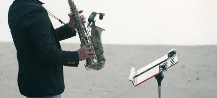 Musikermann, der Saxophon am Strand spielt. foto