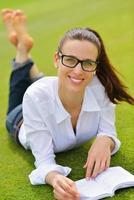 junge Frau, die ein Buch im Park liest foto