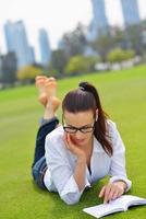 junge Frau, die ein Buch im Park liest foto