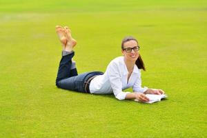 junge Frau, die ein Buch im Park liest foto