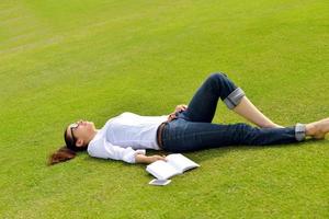 junge Frau, die ein Buch im Park liest foto