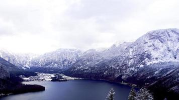 szene von hallstatt winter schnee berglandschaft tal und see durch den wald foto