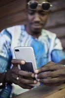 gebürtiger afrikanischer schwarzer Mann mit Smartphone foto