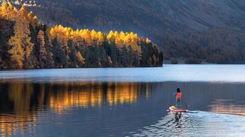 auf Paddleboard im Bergsee im Herbst foto