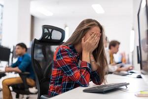 Schöne schockierte und verärgerte junge Frau, die ihren Desktop betrachtet. traurige betreiberagentin, die von zu hause aus in einem callcenter arbeitet foto