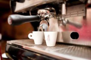 Espressomaschine gießt Kaffee in Tassen foto