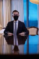 Geschäftsmann mit schützender Gesichtsmaske im Luxusbüro foto