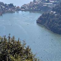 volle ansicht des naini-sees während der abendzeit nahe der einkaufsstraße in nainital, uttarakhand, indien, schöne ansicht des nainital-sees mit bergen und blauem himmel foto