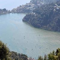 volle ansicht des naini-sees während der abendzeit nahe der einkaufsstraße in nainital, uttarakhand, indien, schöne ansicht des nainital-sees mit bergen und blauem himmel foto