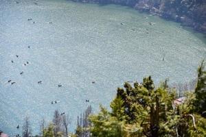 volle ansicht des naini-sees während der abendzeit nahe der einkaufsstraße in nainital, uttarakhand, indien, schöne ansicht des nainital-sees mit bergen und blauem himmel foto