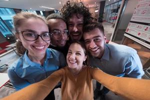 Gruppe von Geschäftsleuten während der Pause von der Arbeit, die ein Selfie-Foto machen, während sie die Freizeit im Entspannungsbereich eines modernen Großraum-Startup-Büros genießen. selektiver Fokus foto