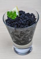 Schwarzer Kaviar in einer Schüssel auf Holzhintergrund foto