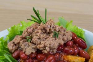 Thunfischsalat in einer Schüssel auf Holzhintergrund foto